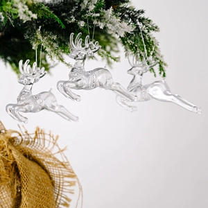 Décoration de Noël en forme de renne transparent suspendue à une branche enneigée