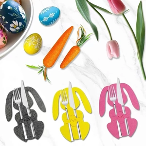 Close-up of colorful rabbit felt cutlery holders on white marble table for Easter dining