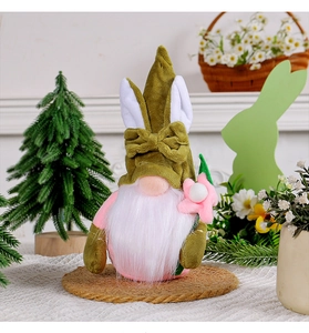 Nahaufnahme von Oster-Wichtel mit grüner Hasenohren-Mütze und kleiner rosa Blume