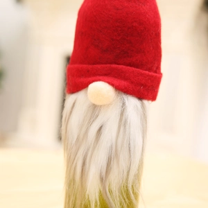 Detail of Christmas gnome wine bottle cover with red felt hat and white faux fur beard