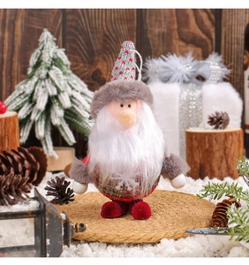 Standing Santa Gnome plush decoration with plaid details in a winter forest scene