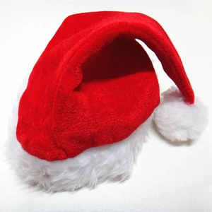 Detail of red velvet Santa hat featuring thick white plush trim and soft faux fur pom-pom