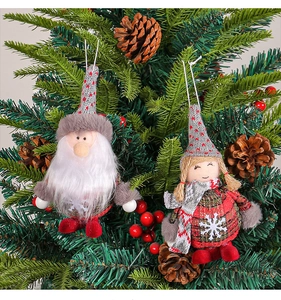 Detail of Christmas gnome and girl ornaments hanging on tree with knitted fabrics