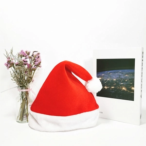 Close-up of a plush red velvet Christmas hat displayed with elegant home decor props