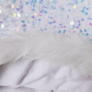 Detailed close-up of white sequin fabric with fluffy faux fur trim for Christmas cape