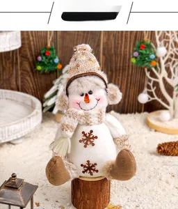 Vue détaillée d'un bonhomme de neige en peluche avec bonnet et écharpe en tricot brun
