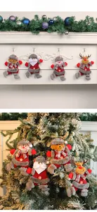 Detail of Christmas plush pendants showing Santa and reindeer hanging on a tree branch