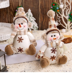 Détails de deux bonhommes de neige en peluche avec écharpes à carreaux et broderies de neige