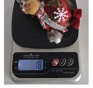 Detail view of a 18g Christmas reindeer plush ornament with red and black plaid fabric