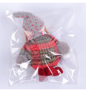 Detailed view of plush Christmas gnome doll featuring knit heart hat and plaid fabric