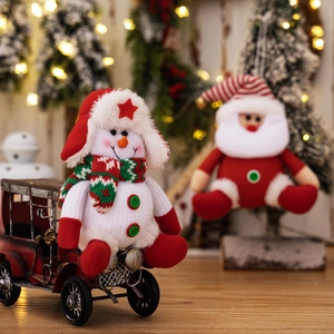Christmas snowman plush doll wearing a red star hat on a vintage red metal toy car