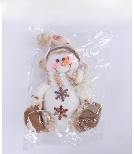 Poupée peluche bonhomme de neige de Noël avec écharpe rayée sous emballage plastique