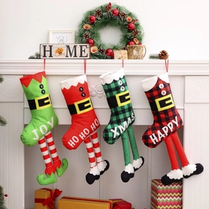 Vue détaillée de quatre chaussettes de Noël en pattes d'elfe sur une cheminée blanche