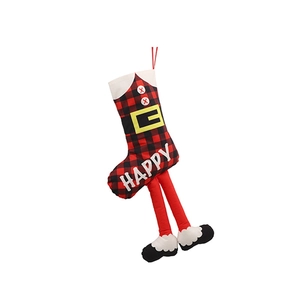 Détail de chaussette de Noël à carreaux rouges et noirs avec texte HAPPY et jambes