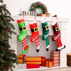 Lot de quatre chaussettes de Noël en forme de jambes d'elfe suspendues à la cheminée