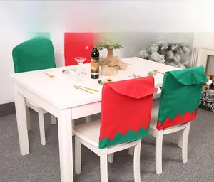 Close-up of red and green elf hat chair covers in a festive Christmas dining setting