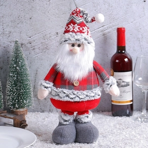Standing Santa Claus doll with red plaid shirt and knitted hat on artificial snow decor
