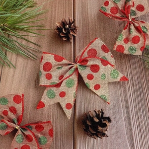 Rustic Christmas linen bows with red and green sequins on a festive wooden background