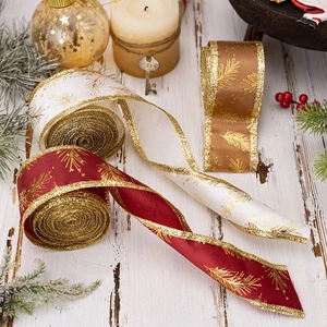 Christmas ribbon with gold glitter edges and pine needle patterns on wooden background