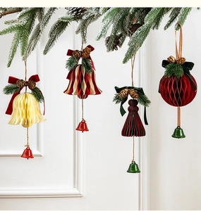 Detail of honeycomb paper Christmas ornaments with velvet bows and pine cones