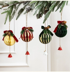 Detailed view of honeycomb Christmas bells with velvet bows and pine cones on snow branches