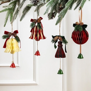 Festive honeycomb paper Christmas ornaments with velvet bows and pine cones on snowy branches