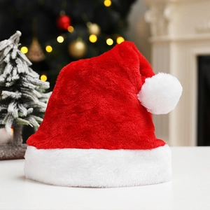 Plush red Christmas hat with soft white faux fur trim and fluffy pompom on white surface