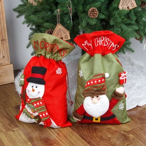Grands sacs cadeaux de Noël avec bonhomme de neige et Père Noël sur tapis en peluche