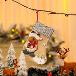 Hanging burlap Christmas stocking with black plaid cuff and plush reindeer doll decor
