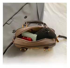Detail view of the brown leather Boston bag showing spacious interior for daily items