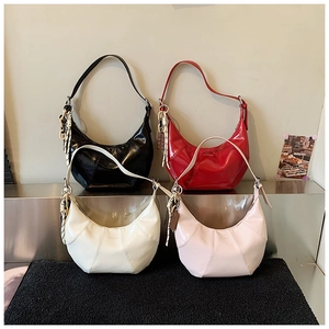 Detailed view of crescent shoulder bags in black, red, cream, and pink glossy leather