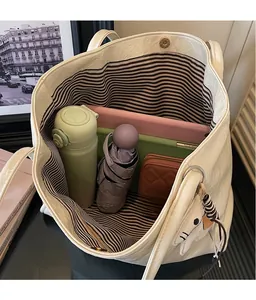 Interior view of large white tote bag showing storage for umbrella and tablet