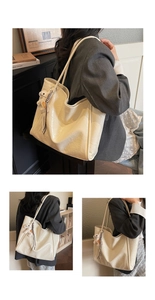 Detail of a large cream-colored tote bag with horse pendant and textured faux leather finish