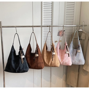 Multiple casual tote bags in five neutral colors hanging neatly on a metal garment rack