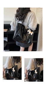 Macro view of black glossy leather tote bag texture and cute horse charm detail