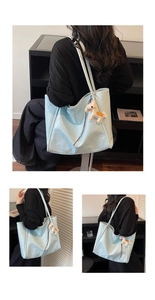 Detail view of large light blue tote bag with a horse charm and shoulder strap