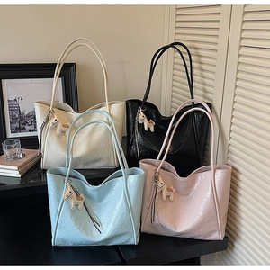 Detail view of large tote bags in four colors with glossy wrinkled texture and horse charms