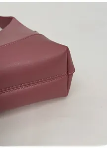 Detail view of the wide base and reinforced stitching on this dusty pink leather shoulder bag