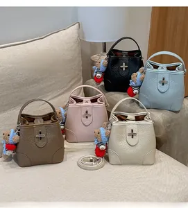 Multiple colors of lychee pattern bucket bags featuring bear pendants and metal closures