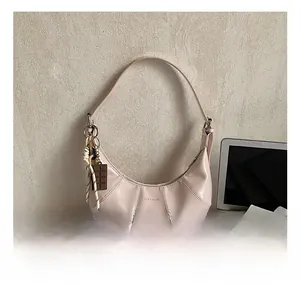 Detail of pink croissant-style crescent bag with unique chocolate charm and woven rope