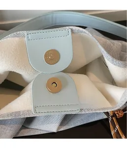 Detail of magnetic snap closure and plush lining on chevron pattern tote bag