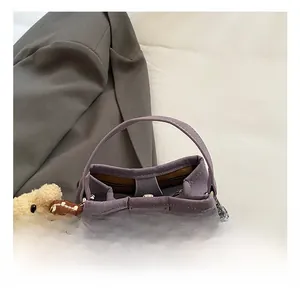 Detail of lavender bucket bag showing textured faux leather handle and bear charm