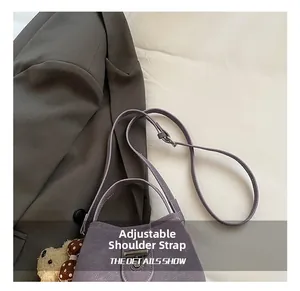 Detail view of lilac bucket bag with adjustable strap and cute teddy bear charm