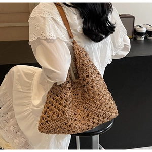 Detail of hollow woven straw beach tote bag with leather strap and radial crochet pattern