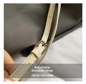 Close-up of adjustable cream leather shoulder strap with silver buckle and fine stitching