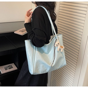 Close-up of light blue crinkled tote bag with a cute pony charm on shoulder strap