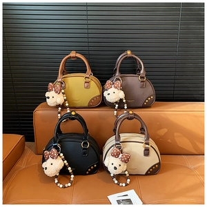 Macro shot of stylish Boston bags in four colors with gold rivets and cute bear charms