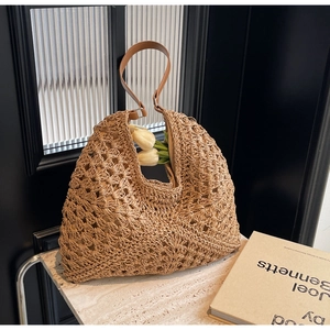 Macro detail of diamond hollow-out woven texture on straw tote with leather strap