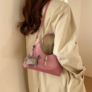 Pink hobo shoulder bag featuring metal buckle and studded horse charm on a model