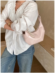 Detailed view of pink leather hobo bag with unique woven knot strap and silver zipper